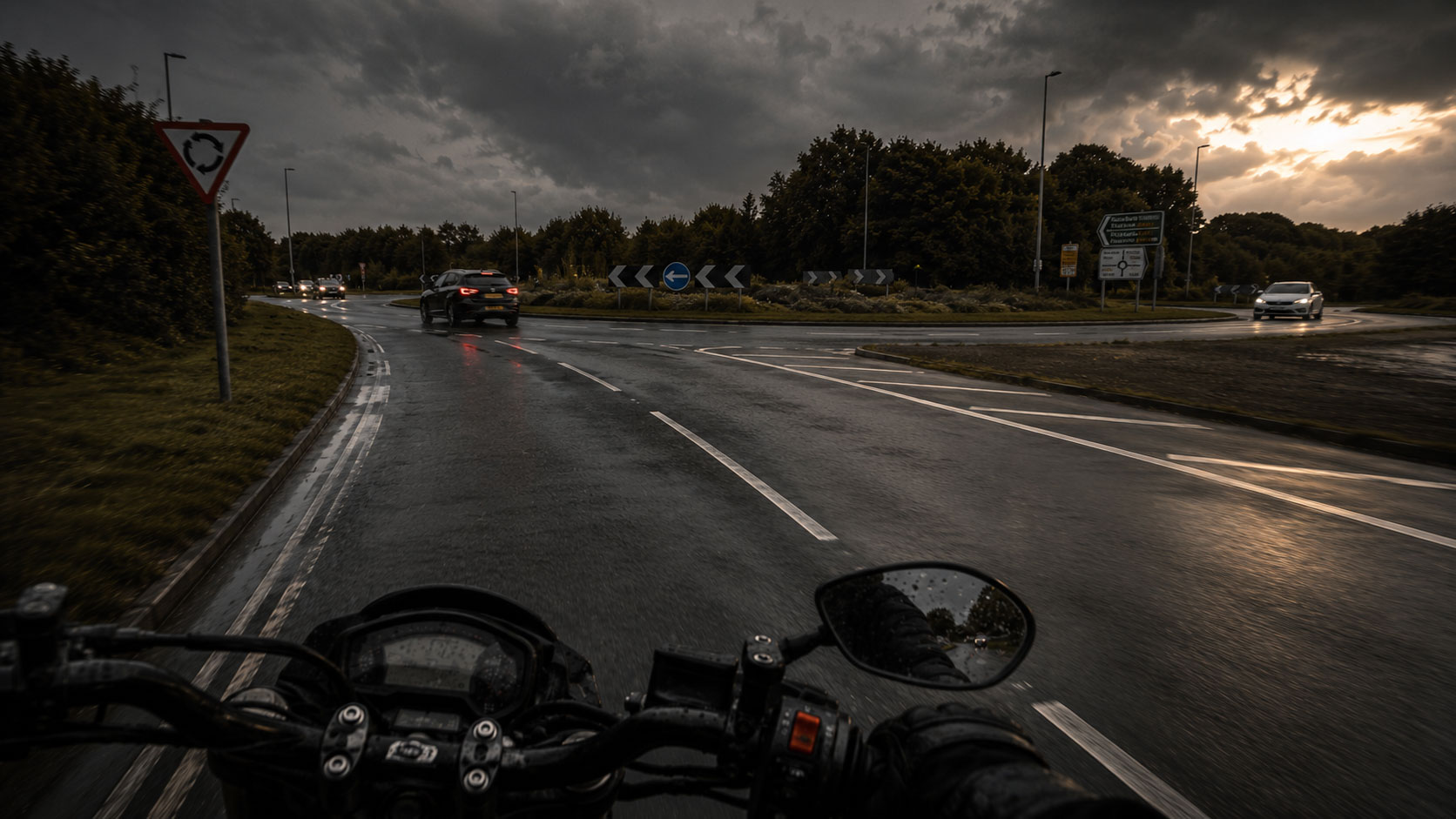 A motorcyclist approaching a roundabout on a wet road